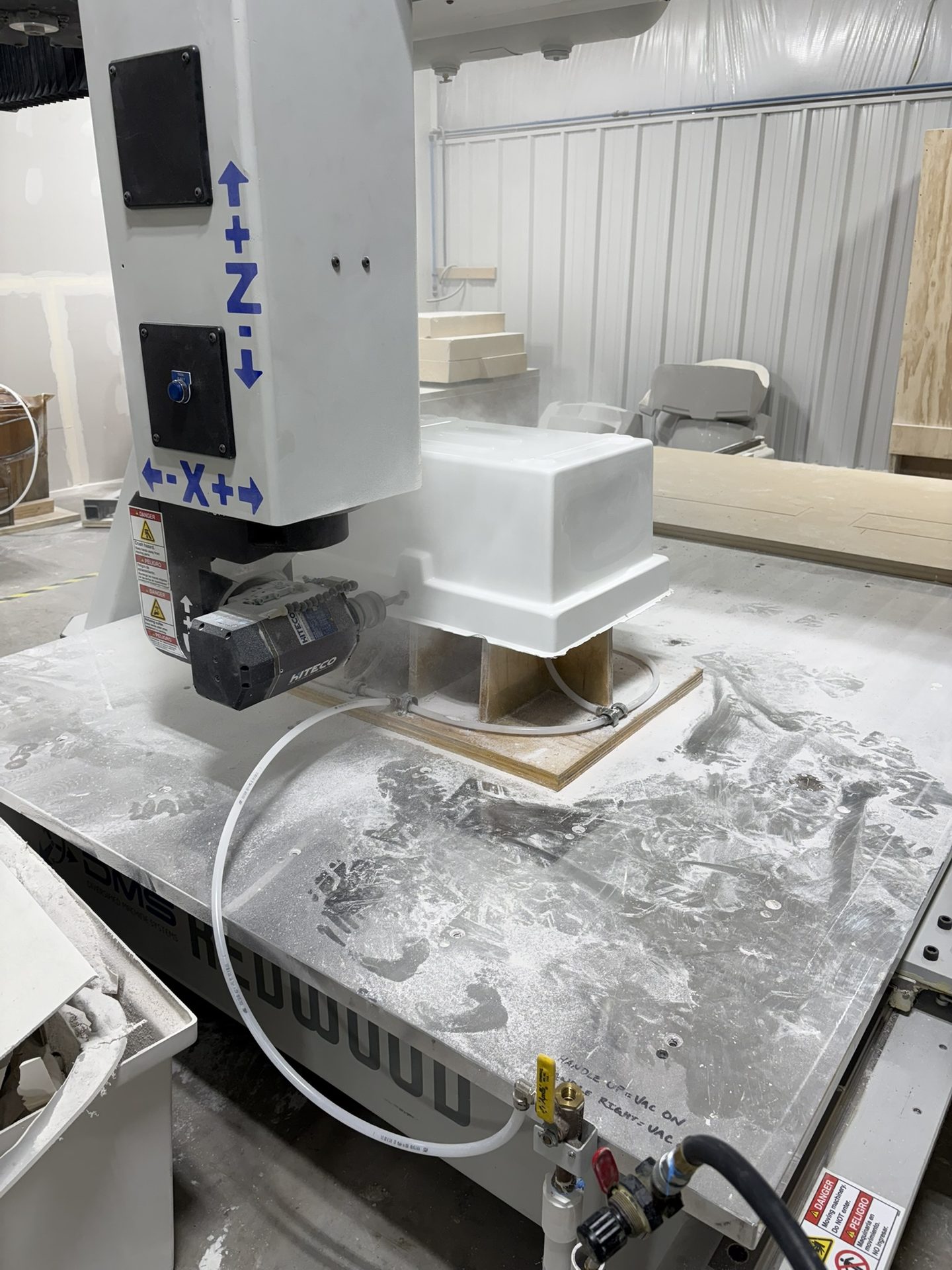 CNC machine over a white molded part