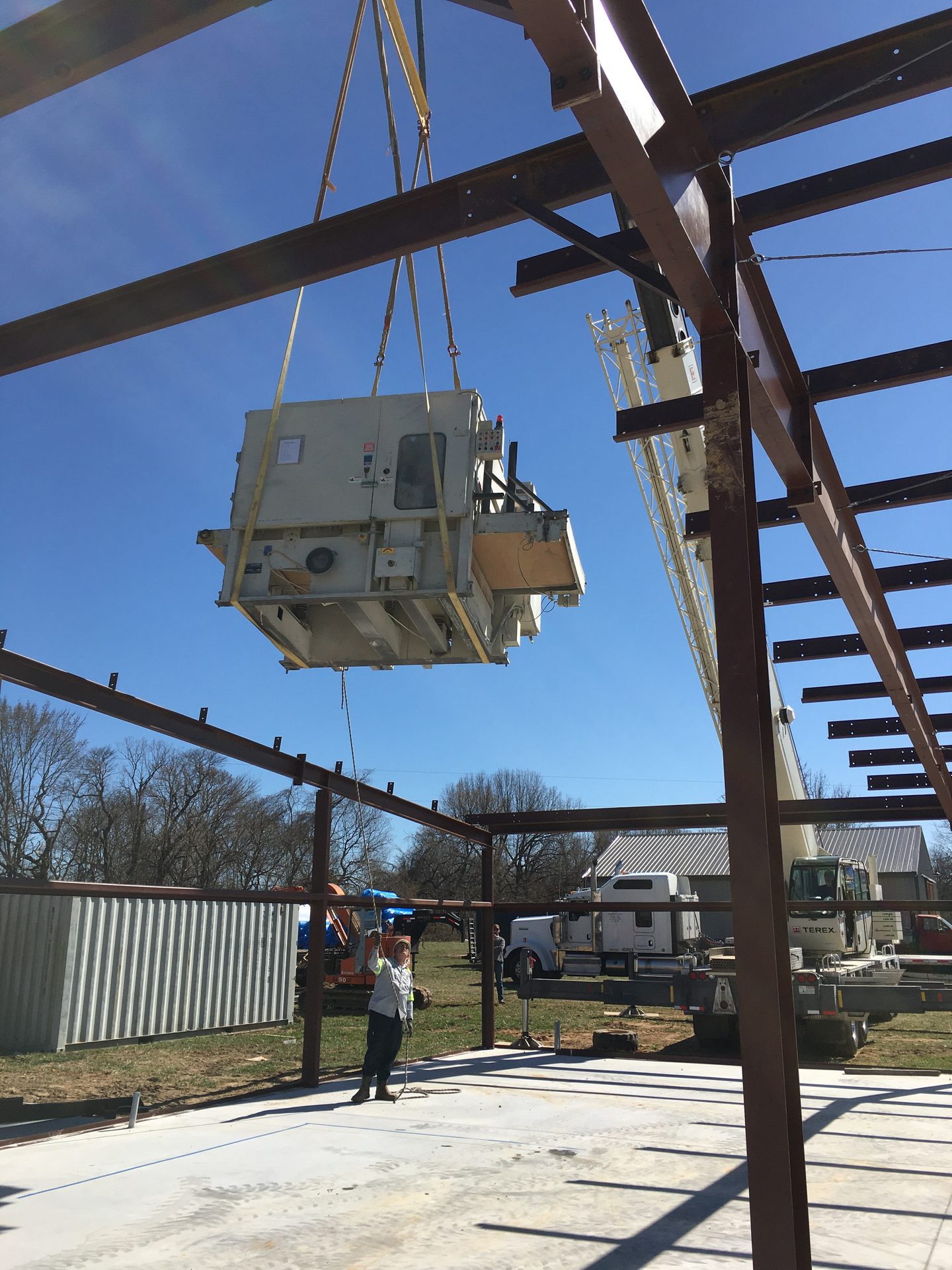 Crane setting a fiberglass equipment enclosure