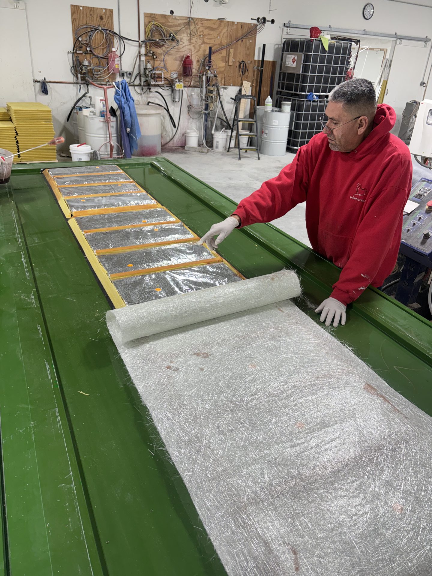 Rolling fiberglass reinforcement across a long panel mold