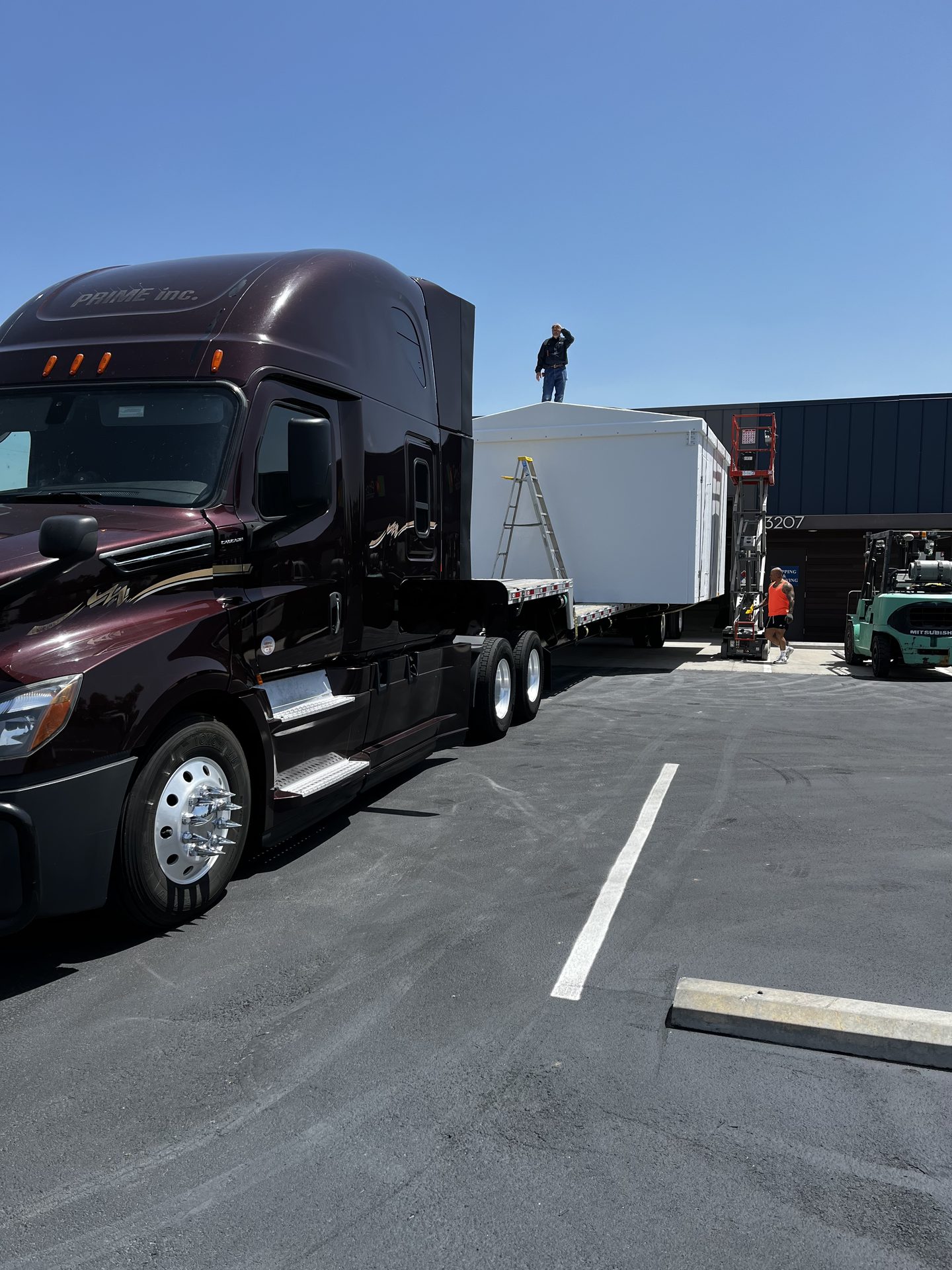 Semi truck hauling a white modular building