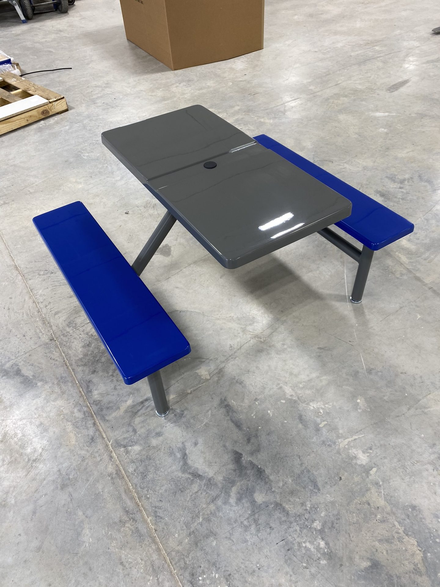 Gray fiberglass picnic table with blue benches