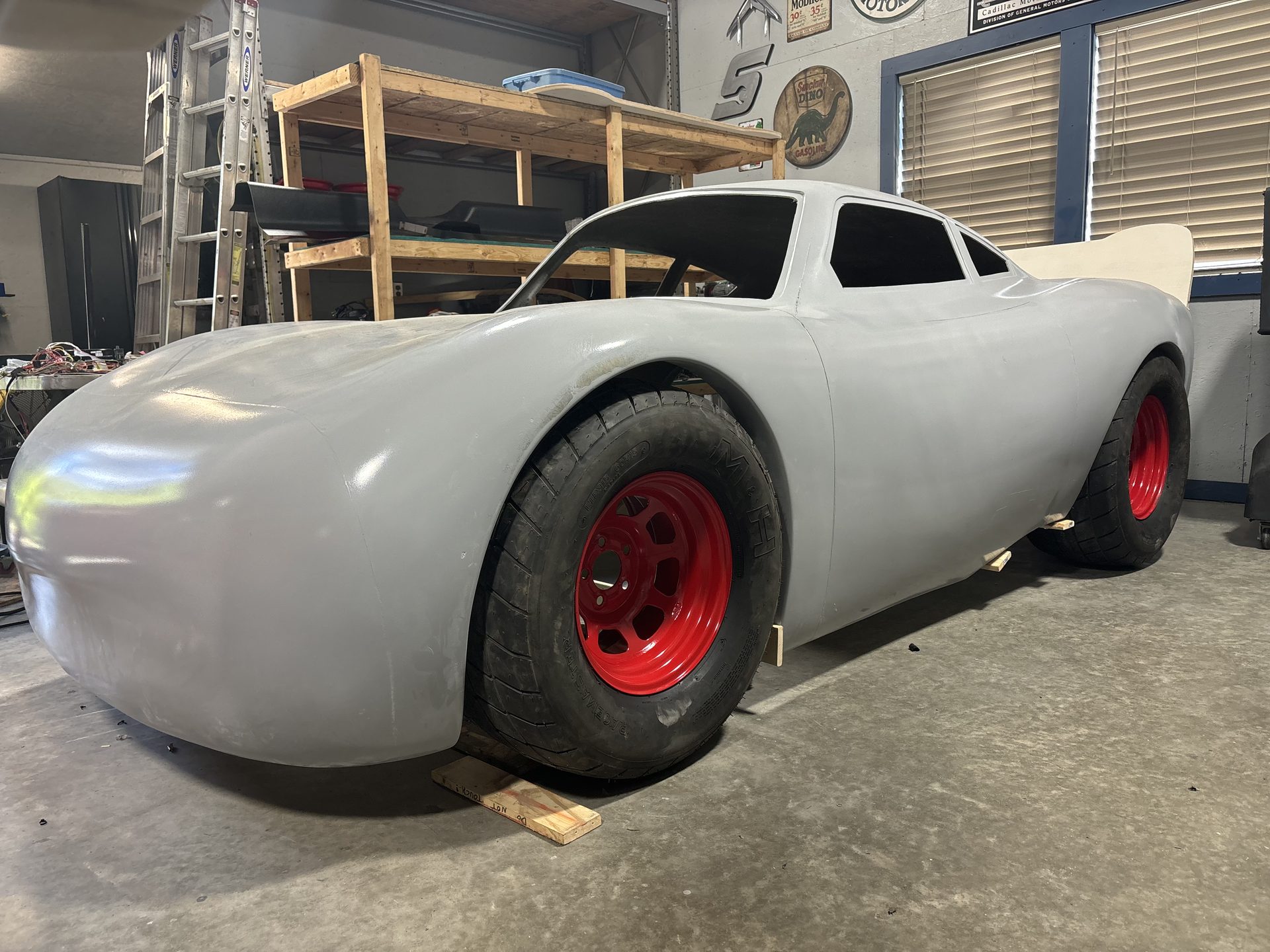 Fiberglass stock car body on red wheels
