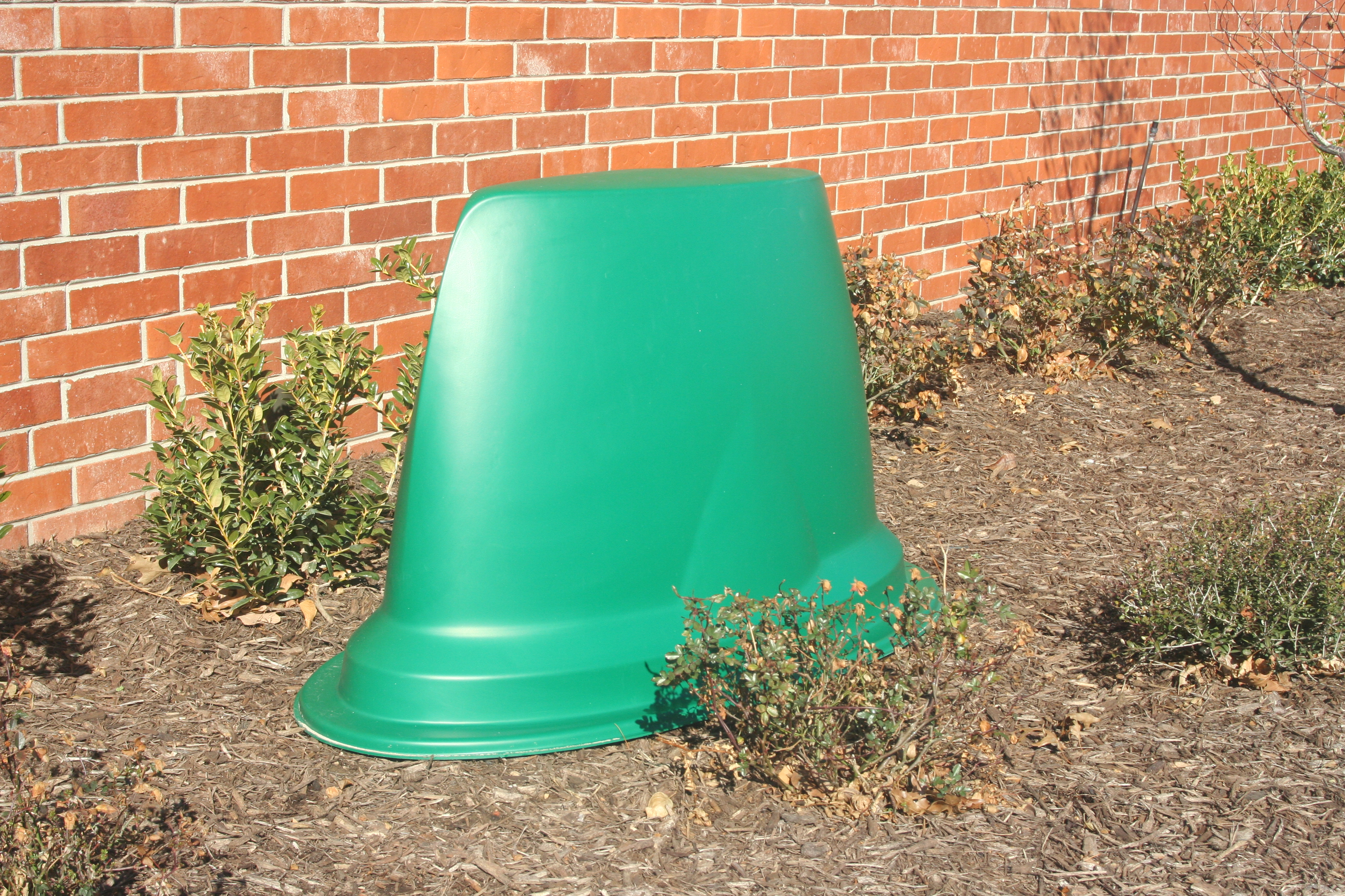 Green Rbox enclosure installed near a brick wall